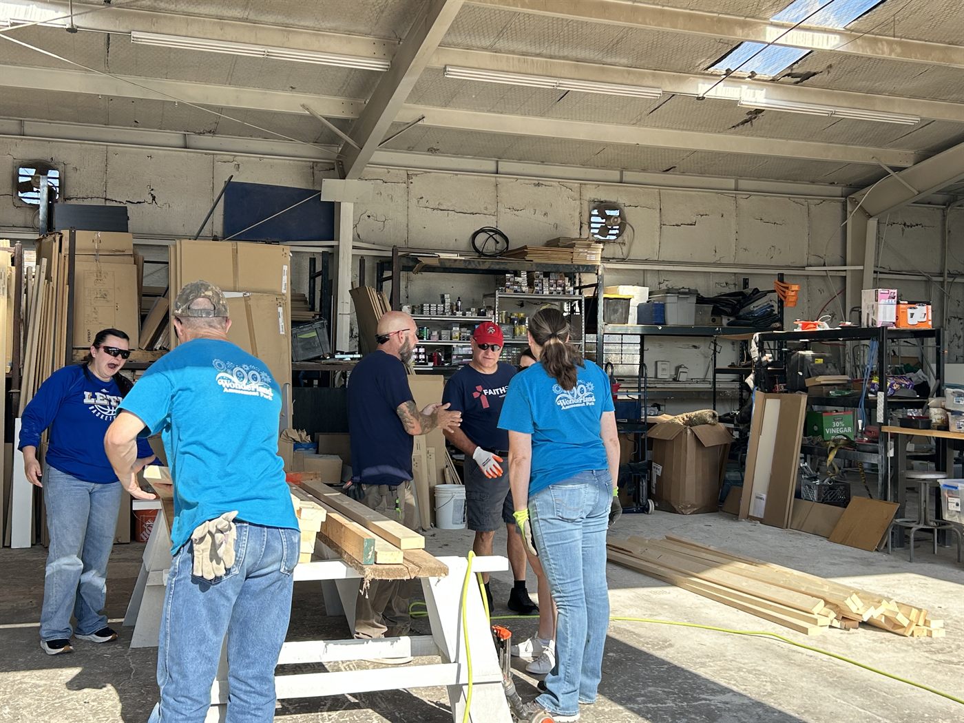 Faith SW volunteers preparing lumber inside the Habitat for Humanity workshop