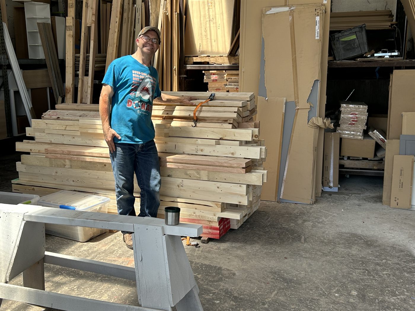 A Faith SW volunteer standing near completed boards for Habitat for Humanity