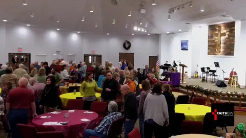 The Faith SW church family gathered around tables in the sanctuary