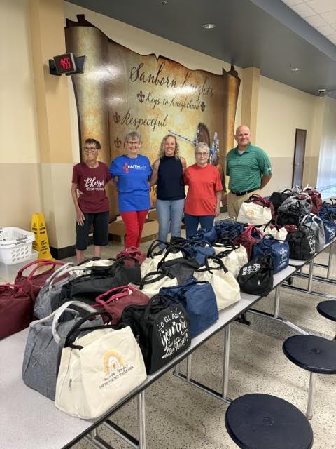 Faith SW volunteers with donated school supplies at Sanborn Elementary School